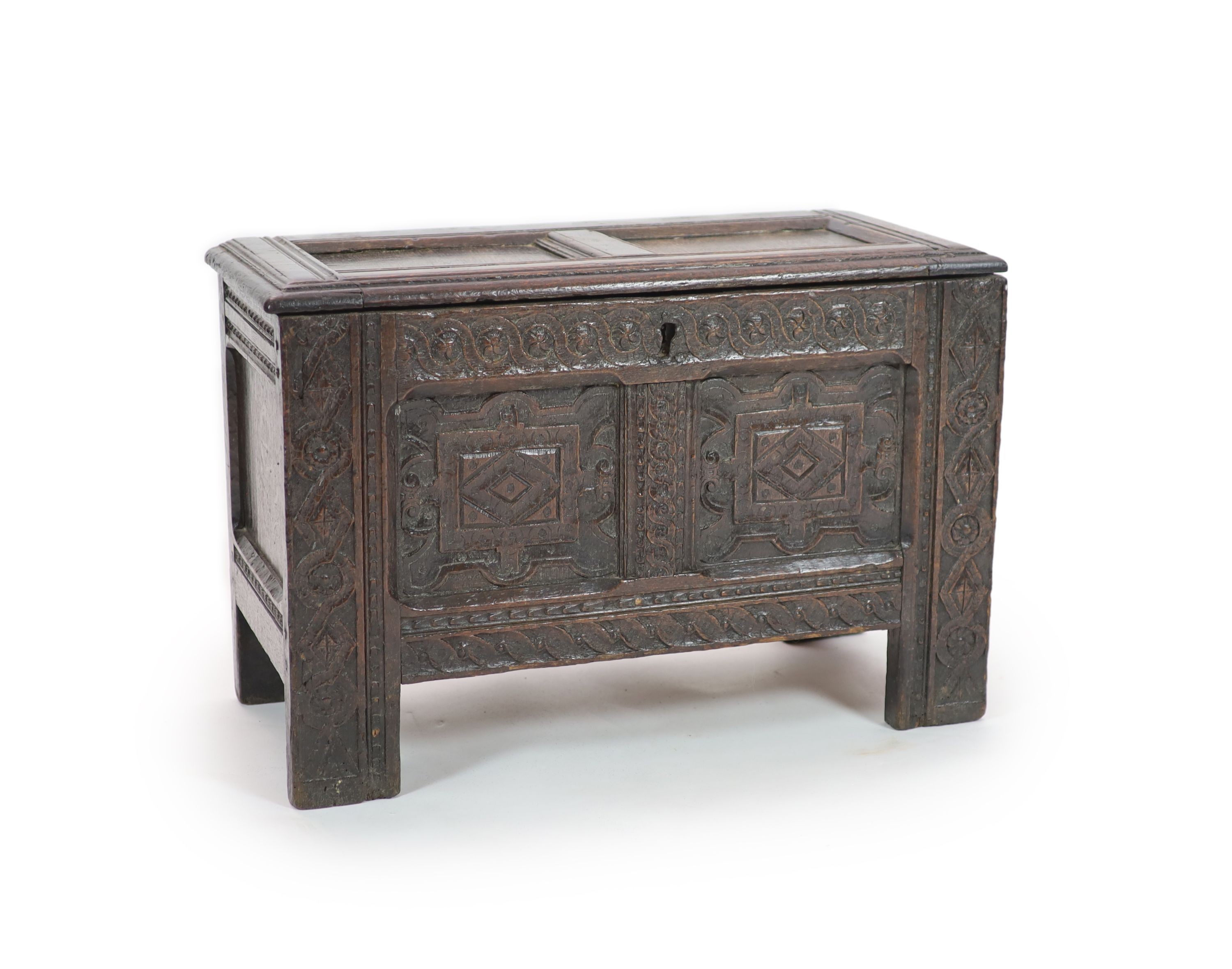 A late 17th/early 18th century small oak coffer (possibly West Country) the panelled front with Renaissance style carving H 46cm. W 70cm. D 34cm.